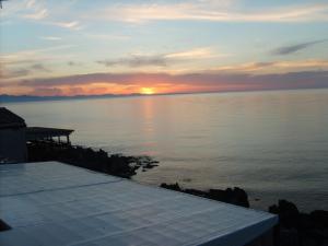 a sunset over a body of water with a dock at Ammaresiamo LTB in Cefalù
