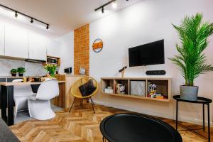 a living room with a table and a tv on a wall at KOZAcki Kwadrat in Lublin