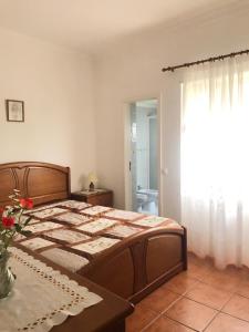 Schlafzimmer mit einem Bett, einem Tisch und einem Fenster in der Unterkunft Apartamento T2 in Nazaré
