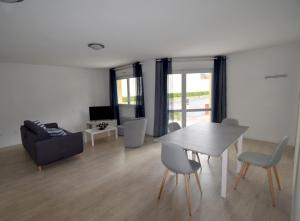 a living room with a table and chairs and a couch at Chez Patrick in Grandcamp-Maisy