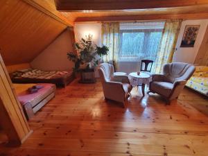 a living room with chairs and a bed and a table at Agroturystyka LAS i WODA in Prażmów