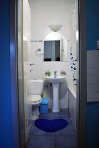 bagno con servizi igienici, lavandino e specchio di Apartments REST - Centar a Novi Sad
