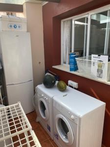 eine Küche mit einer Waschmaschine und einem Kühlschrank in der Unterkunft Golf Chalet Islantilla in Islantilla