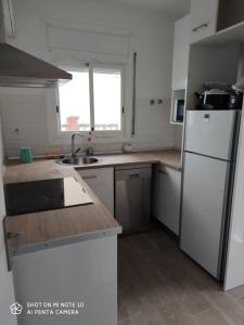 a kitchen with a white refrigerator and a sink at Estancia Rural Tranquila in Lliçà d'Amunt