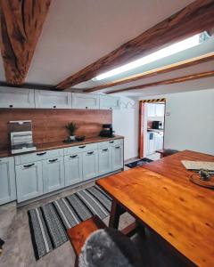 a kitchen with white cabinets and a wooden table at Gästehaus Alpenglühn in Meien