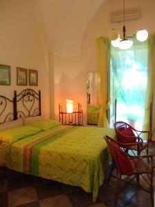 a bedroom with a bed and two chairs and a window at Leziedipiero in Nardò