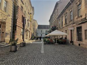 an empty street with an umbrella and tables and chairs at ZOR ZON studios in Timişoara