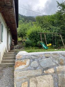 a stone wall with a playground in a yard at Chalet Le Triollet in Saint-Gervais-les-Bains