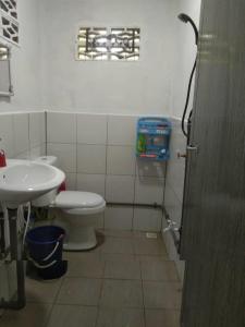 La salle de bains est pourvue de toilettes blanches et d'un lavabo. dans l'établissement Haji Ineng Homestay- Guest House, à Kota Samarahan