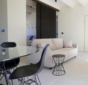 a living room with a white couch and a glass table at SETTANNI Sea Suites in Polignano a Mare