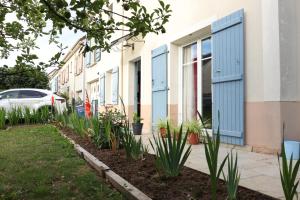 a row of houses with blue doors and plants at Ma Grace in Savigny-le-Temple