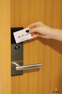 una persona sosteniendo un pedazo de papel en una puerta en Asa Branca Hotel, en Araripina