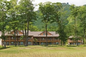 a large house in the woods with trees at Jay Peak Resort in Jay