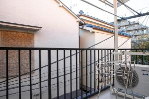 a balcony with a black fence and a fan at Horikiri Kodate - Vacation STAY 8860 in Tokyo