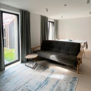 a living room with a black couch and a table at Apartment KOPA in Pervalka