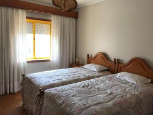 1 dormitorio con 2 camas y ventana en Alamar Barra, en Praia da Barra