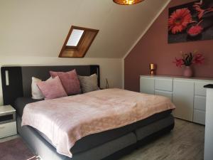 Ferienhaus Elsa في Kranichfeld: غرفة نوم مع سرير كبير مع وسائد وردية
