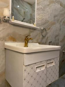 ein weißes Badezimmer mit einem Waschbecken und einem Spiegel in der Unterkunft جواهر الشرق للوحدات السكنية in Riad
