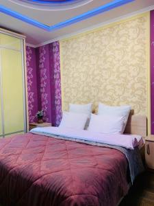 a bedroom with a large bed with purple walls at Elit in Romny