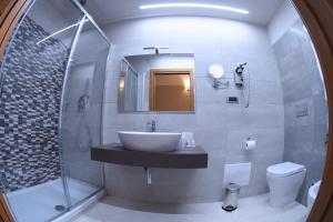 a bathroom with a sink and a mirror and a toilet at Hotel Niagara in Catanzaro Lido