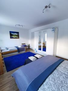 a bedroom with a blue bed and a mirror at 4P Apartment in Andermatt