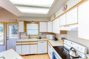 a kitchen with white cabinets and white appliances at Tanya's Beach Retreat in Pacific City