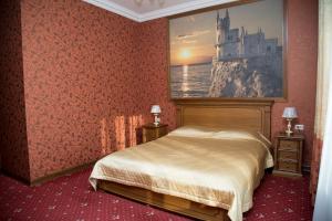 a bedroom with a bed and a picture of a castle at Rossiya Hotel in Vol'sk