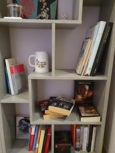 a book shelf filled with books and a coffee mug at Giolitti Luxury Apartment in Cuneo