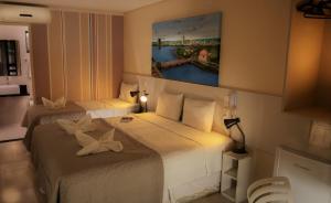une chambre d'hôtel avec 2 lits et un tableau mural dans l'établissement Pousada Elo Inn, à Récife