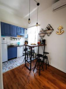 een keuken met blauwe kasten en een tafel en stoelen bij Apartman nono Ive in Vis