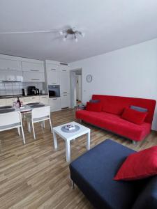 - un salon avec un canapé rouge et une table dans l'établissement 4P Apartment, à Andermatt