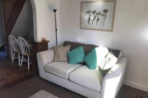 a living room with a white couch with blue pillows at Attractive 2 bed cottage in Hempton Fakenham in Fakenham