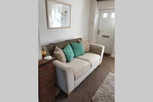 a living room with a couch with blue pillows at Attractive 2 bed cottage in Hempton Fakenham in Fakenham