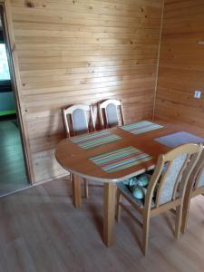 einen Holztisch und Stühle in einem Zimmer in der Unterkunft Domki Orla in Pasym
