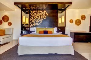 een slaapkamer met een groot wit bed en een bank bij Royalton Punta Cana, An Autograph Collection All-Inclusive Resort & Casino in Punta Cana