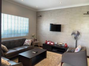 ein Wohnzimmer mit einem Sofa und einem Flachbild-TV in der Unterkunft [B] Bakerstreet - Beautiful Two Bedroom Apartment in Accra