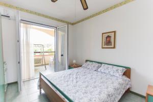 1 dormitorio con 1 cama y puerta corredera de cristal en Incantevole Villetta mare indipendente en Marina di Pisticci