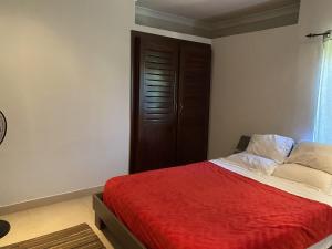 ein Schlafzimmer mit einem Bett mit einer roten Decke in der Unterkunft [B] Bakerstreet - Beautiful Two Bedroom Apartment in Accra