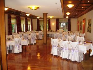a banquet hall with white tables and white chairs at Wald-Café Hotel-Restaurant in Bonn