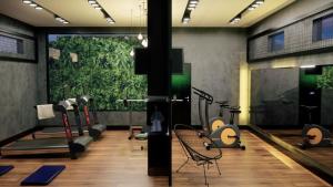 a room with a gym with a green wall at Brii Hotel in Araguaína
