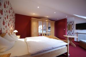 a bedroom with a white bed and a red wall at Wald-Café Hotel-Restaurant in Bonn +16 photos