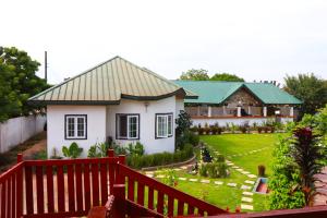 una pequeña casa blanca con techo verde en Northwood Gardens, en Accra