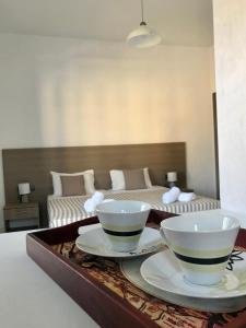 two bowls on a tray with a bed in the background at Lena Apartments in Elounda