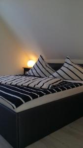 una cama con almohadas a rayas en una habitación en FeWo Oberdeck Ueckermünde, en Ueckermünde