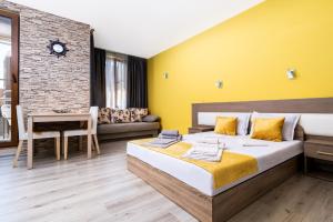 ein Schlafzimmer mit einem großen Bett und einer gelben Wand in der Unterkunft Modern Studios - Meters away from the beach in Pomorie