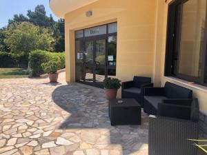 a patio in front of a building with two chairs at Hotel Ristorante111 in Villapiana