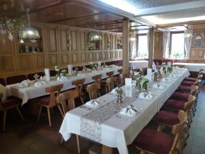 uma sala de jantar com mesas e cadeiras brancas em Hotel Gasthof Krapp em Scheßlitz
