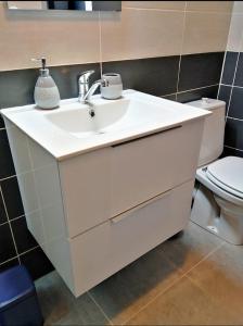 a bathroom with a white sink and a toilet at T2 bis quartier château de Pau in Pau +11 photos