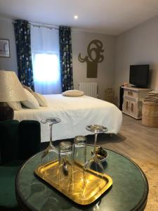 Cette chambre comprend un lit et une table avec des verres. dans l'établissement Cloutiers26, à La Rochelle