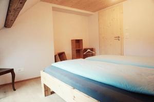 Schlafzimmer mit einem Bett, einem Tisch und einer Tür in der Unterkunft NEU renoviert - Bitzi Appenzell – Mit Aussicht in Appenzell